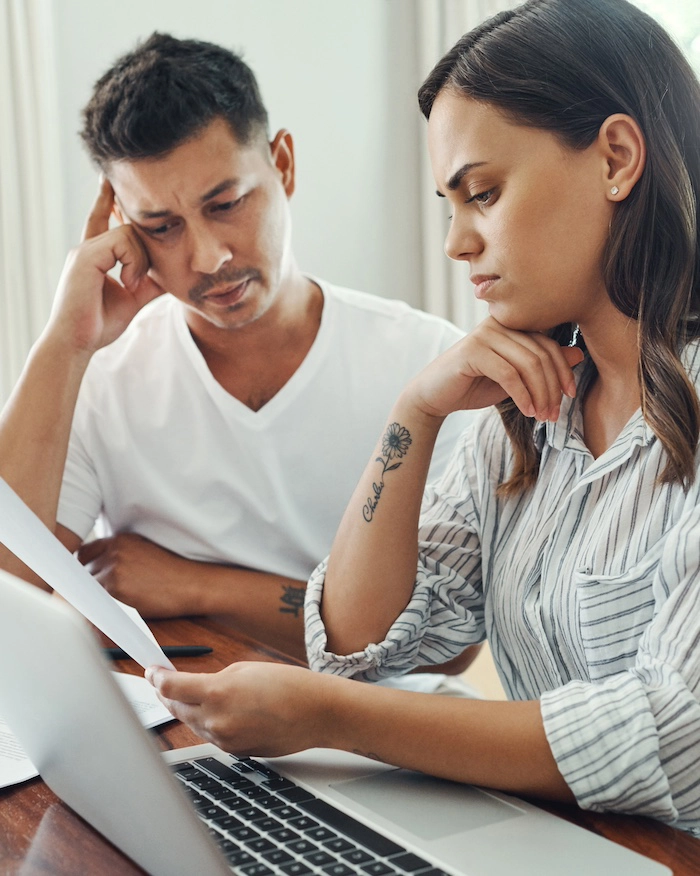 Stressed couple examine credit report with error Stressed couple examine credit report with error